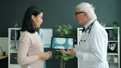 Doctor showing a patient a medical scan on a tablet