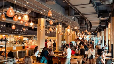 A crowded, noisy restaurant filled with diners at tables, the kind of challenging listening environment assistive listening devices help with